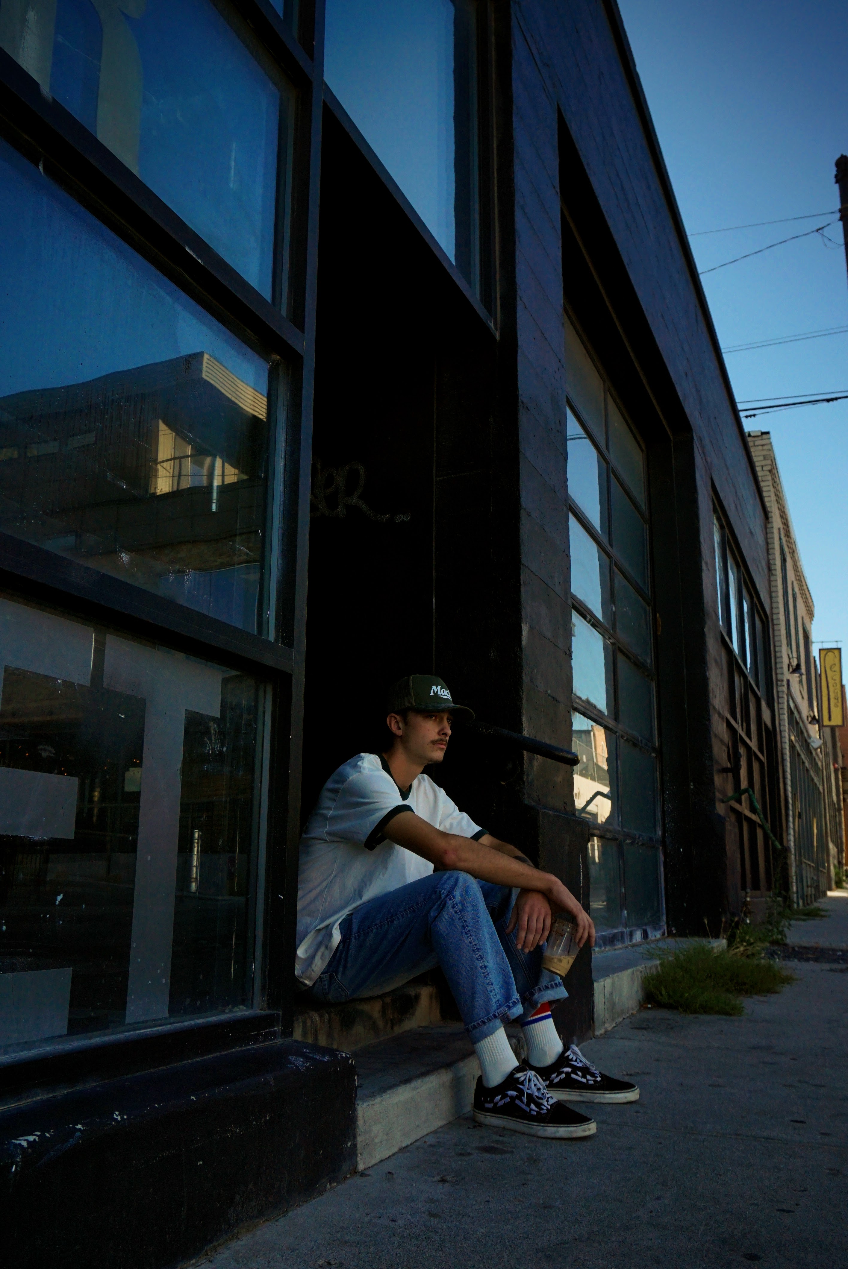 Portrait — Young man seated outside in blue light