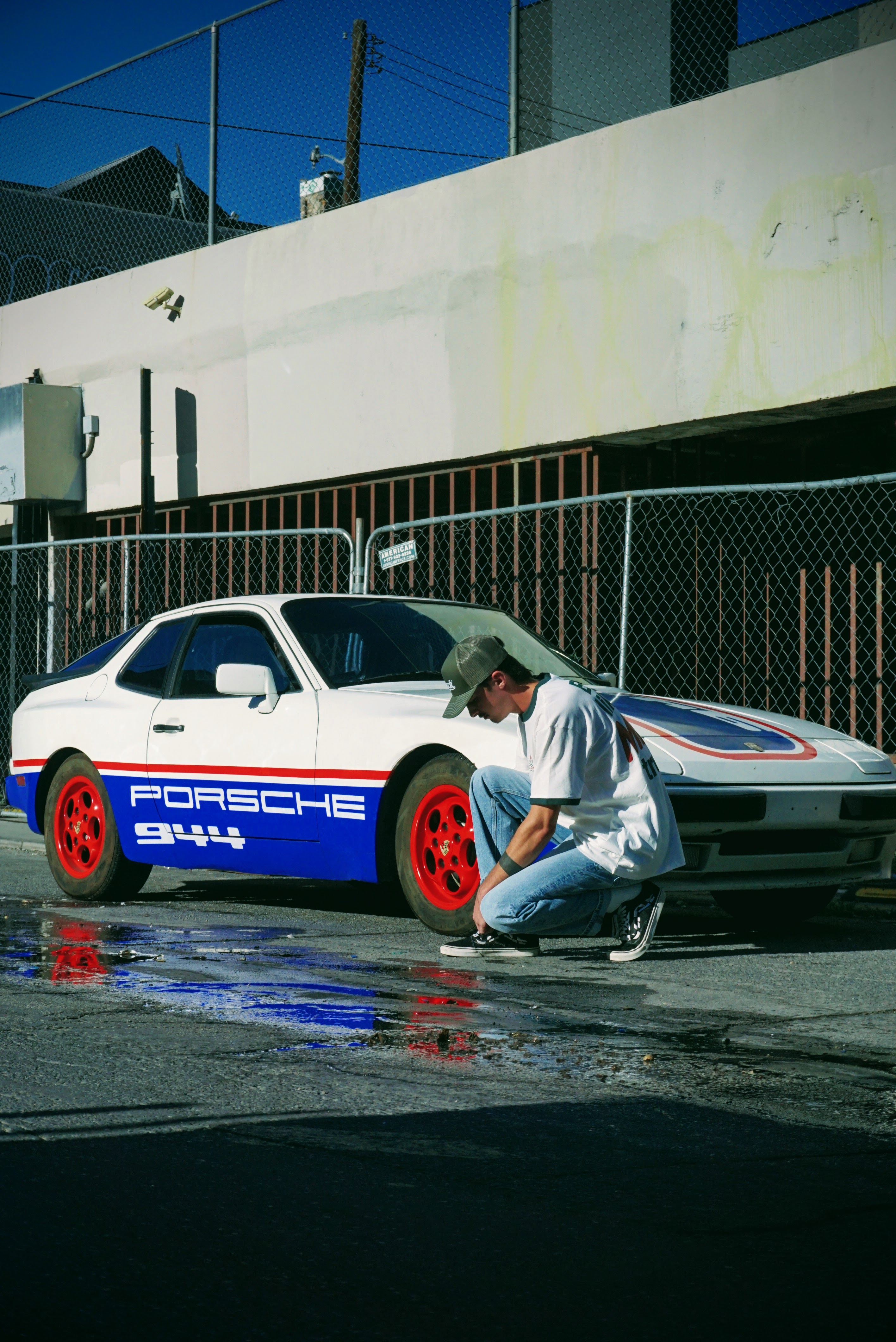 Lifestyle — Man crouched beside a vintage Porsche