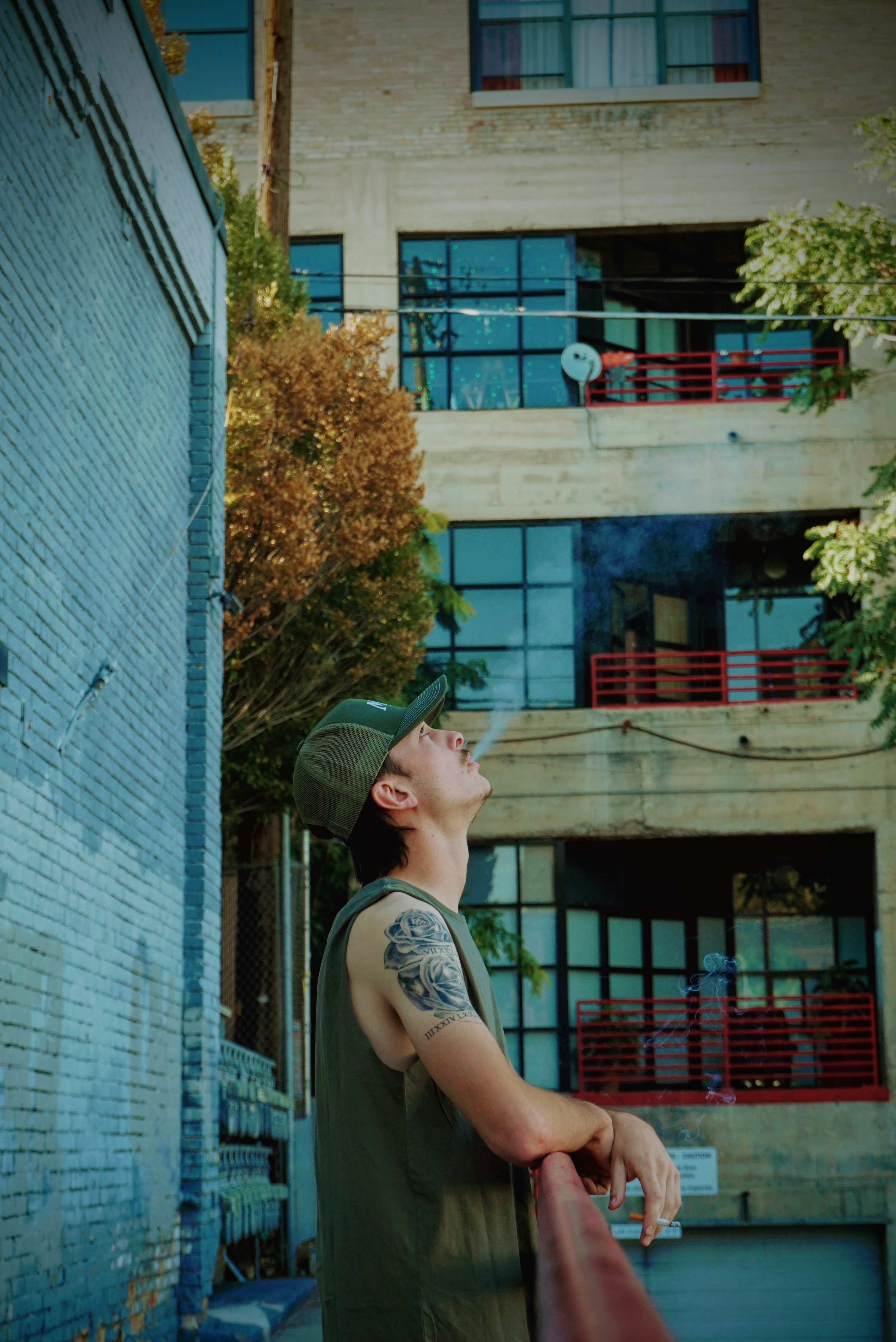 Portrait — Man gazing upward in a colorful urban alley