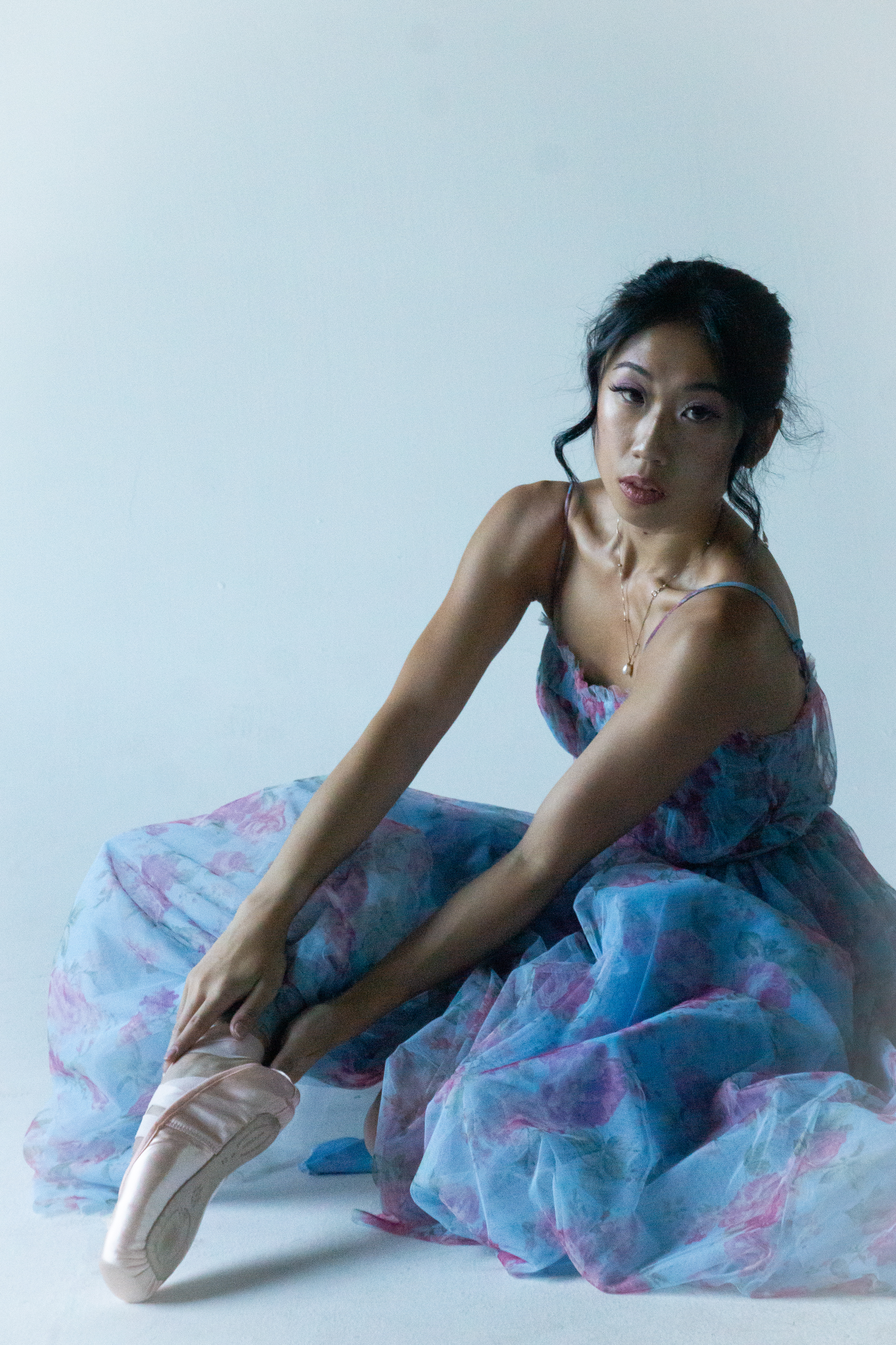 Fashion — Ballerina in a blue floral dress on studio floor