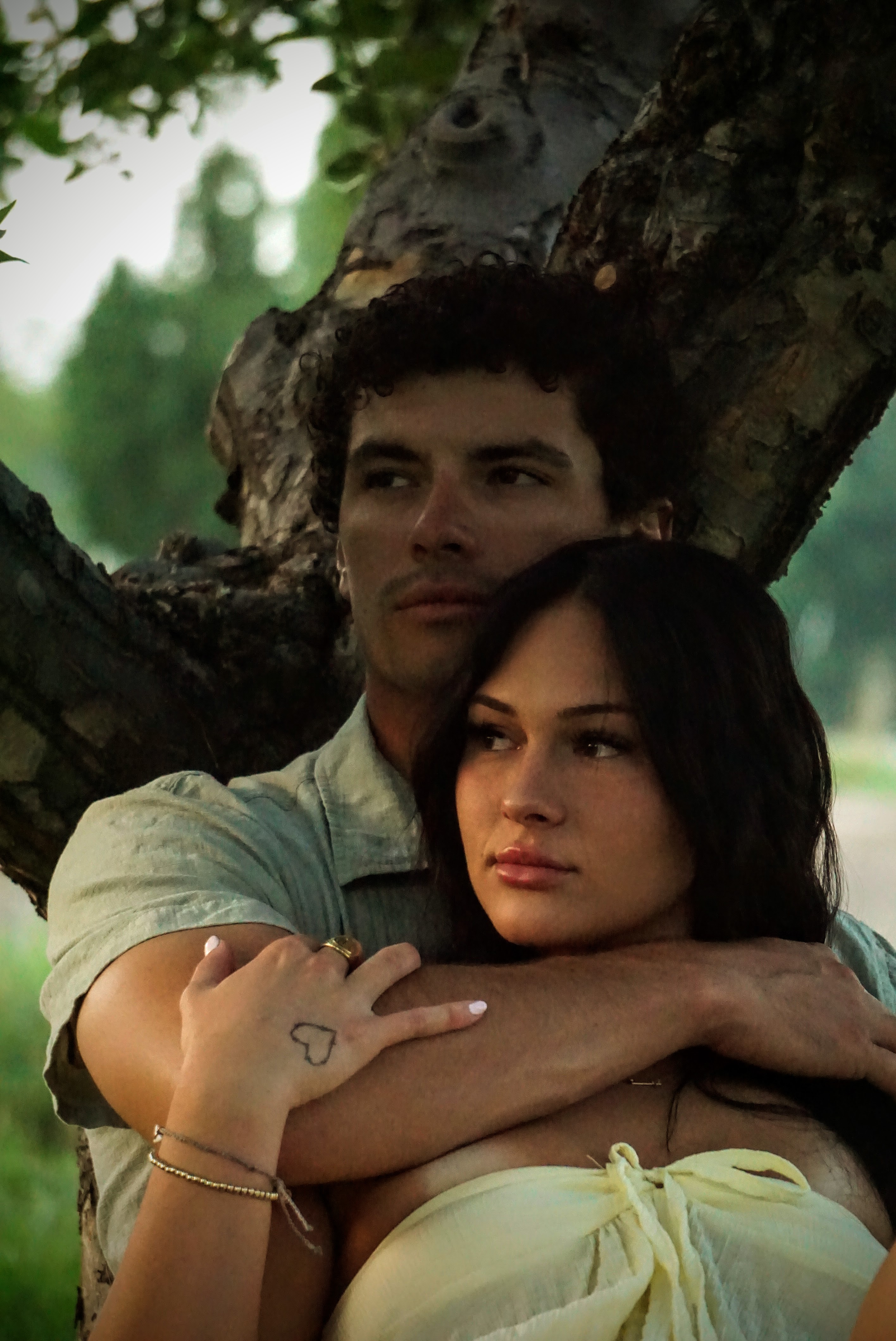 Couples photography — two people embracing by a tree