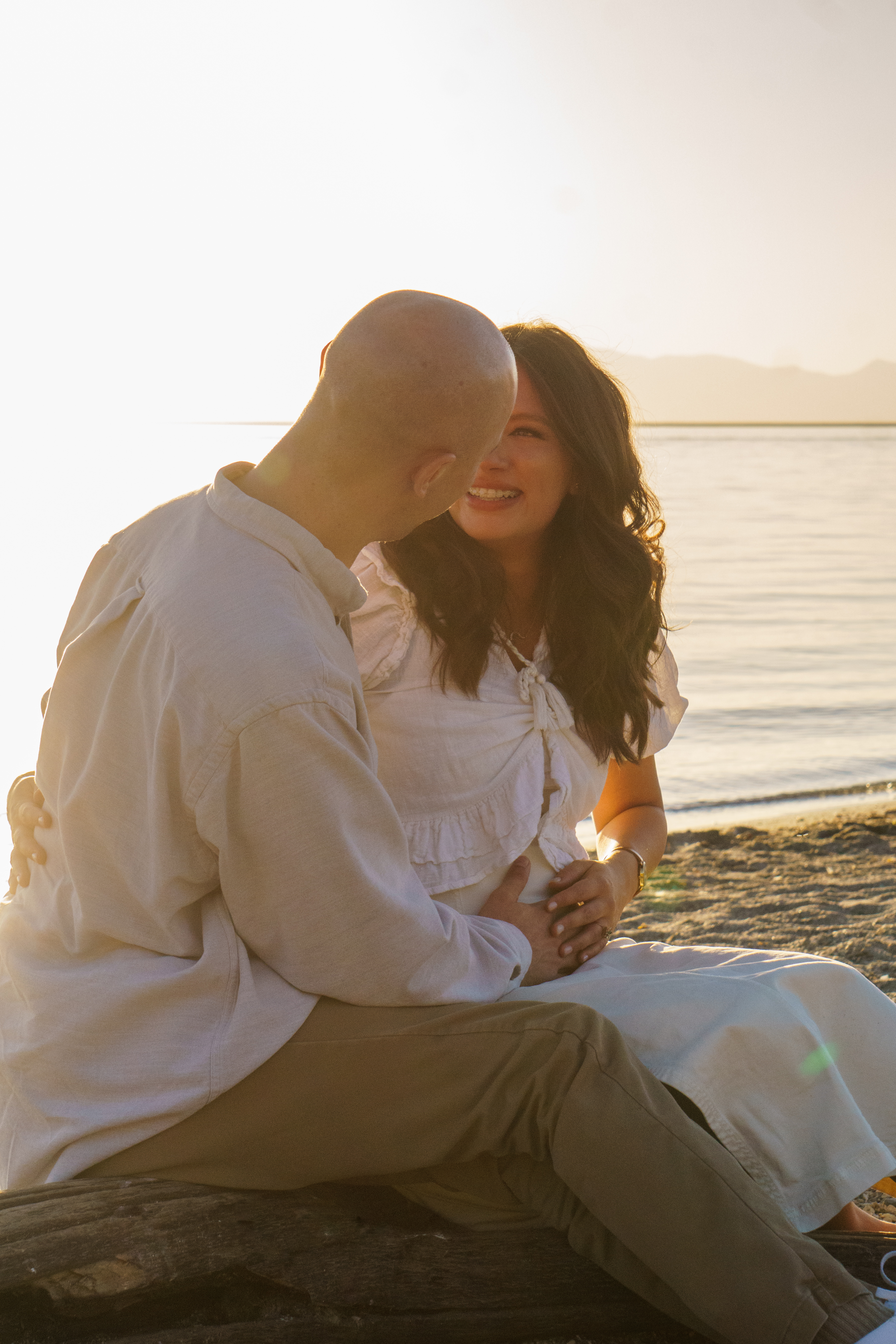 Lifestyle — Couple laughing together at golden hour by the water