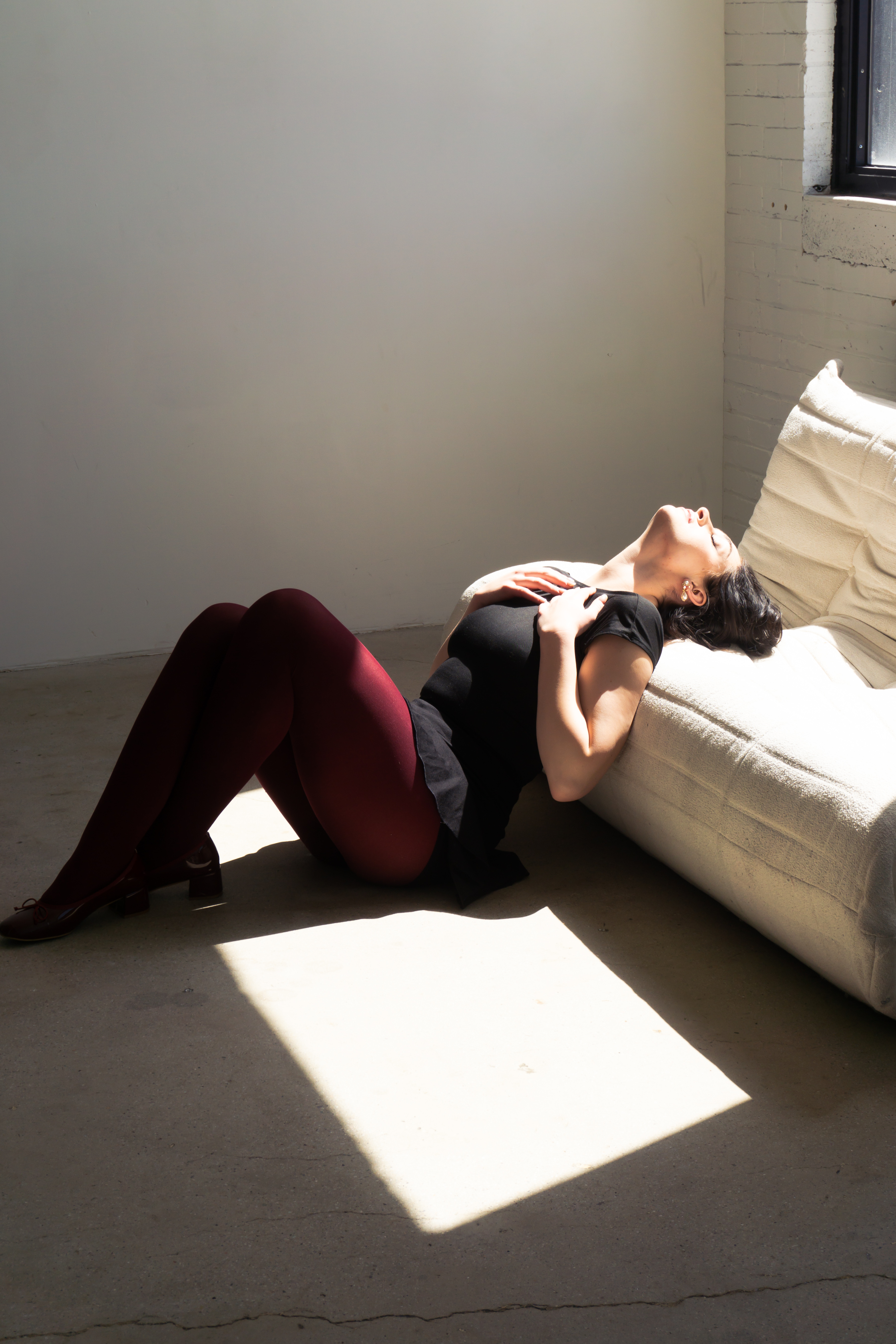 Fashion — Woman lying back in dramatic window light