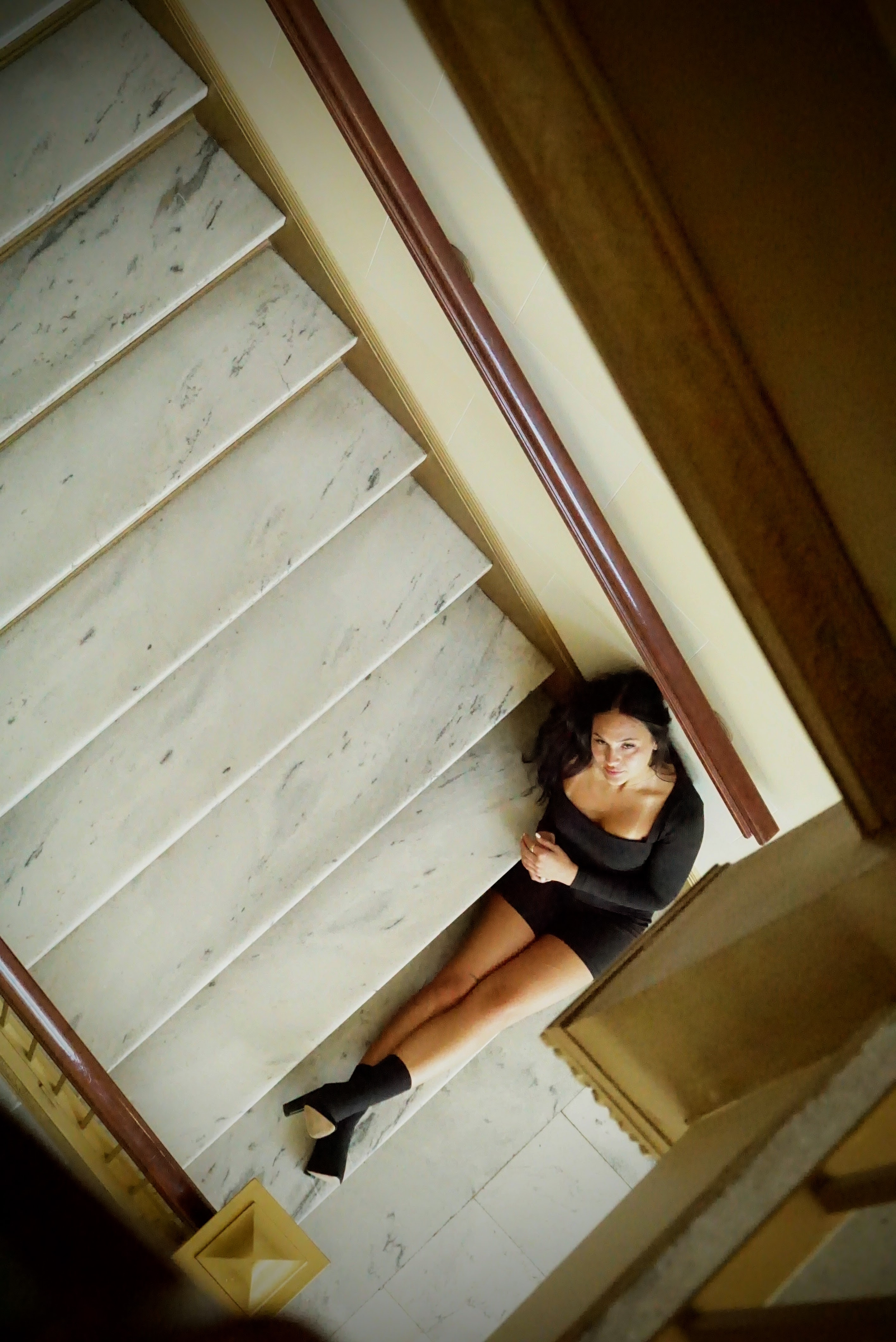 Fashion — Looking down at a woman posed on marble stairs