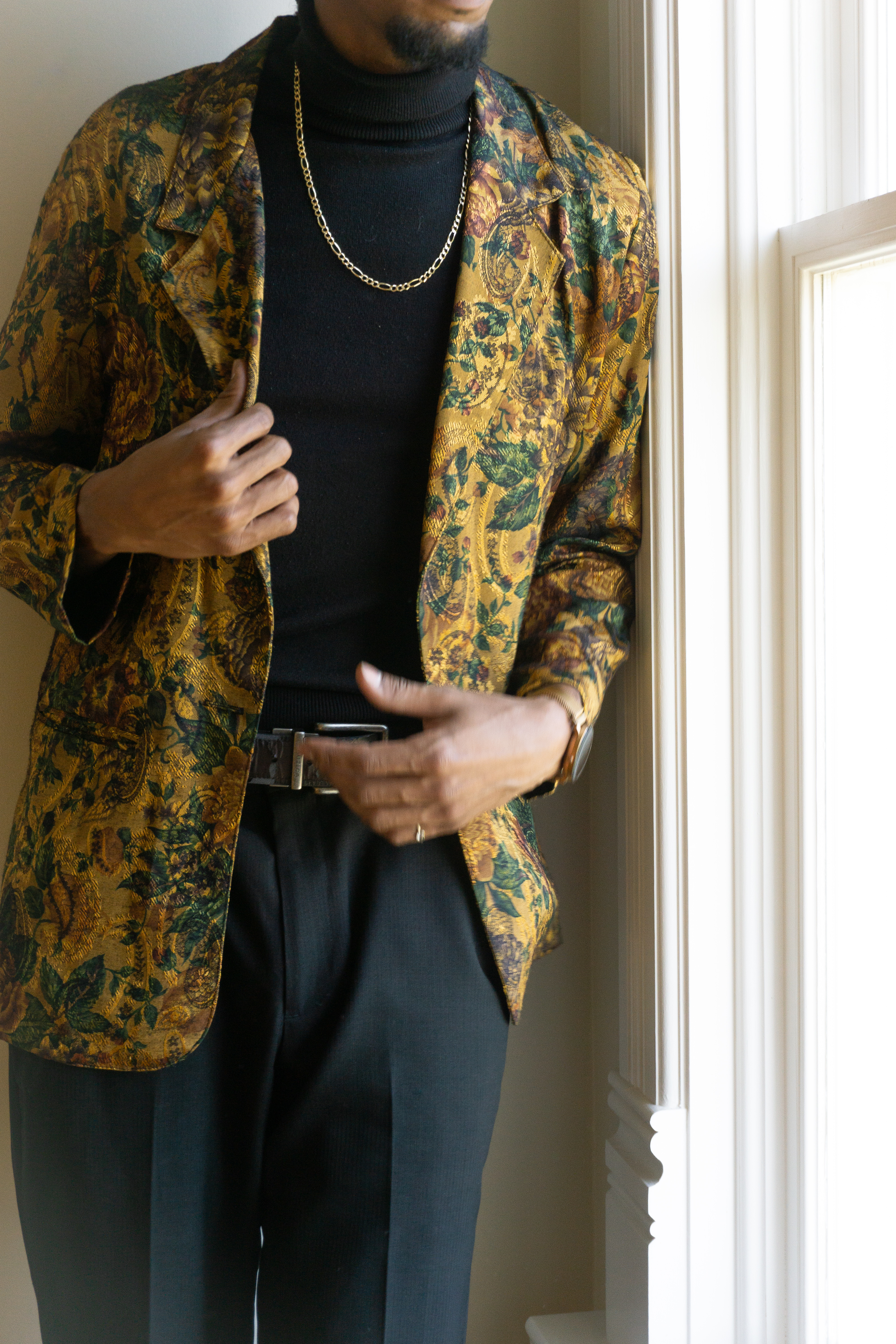 Portrait — Man in a bold patterned jacket by a window