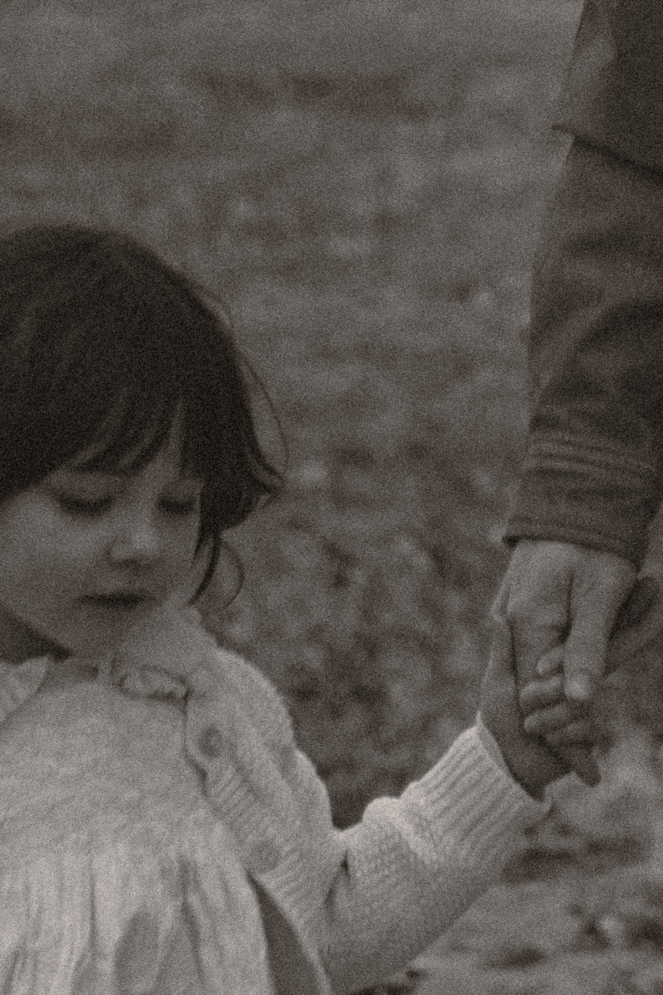 Family — Child and parent holding hands in black and white