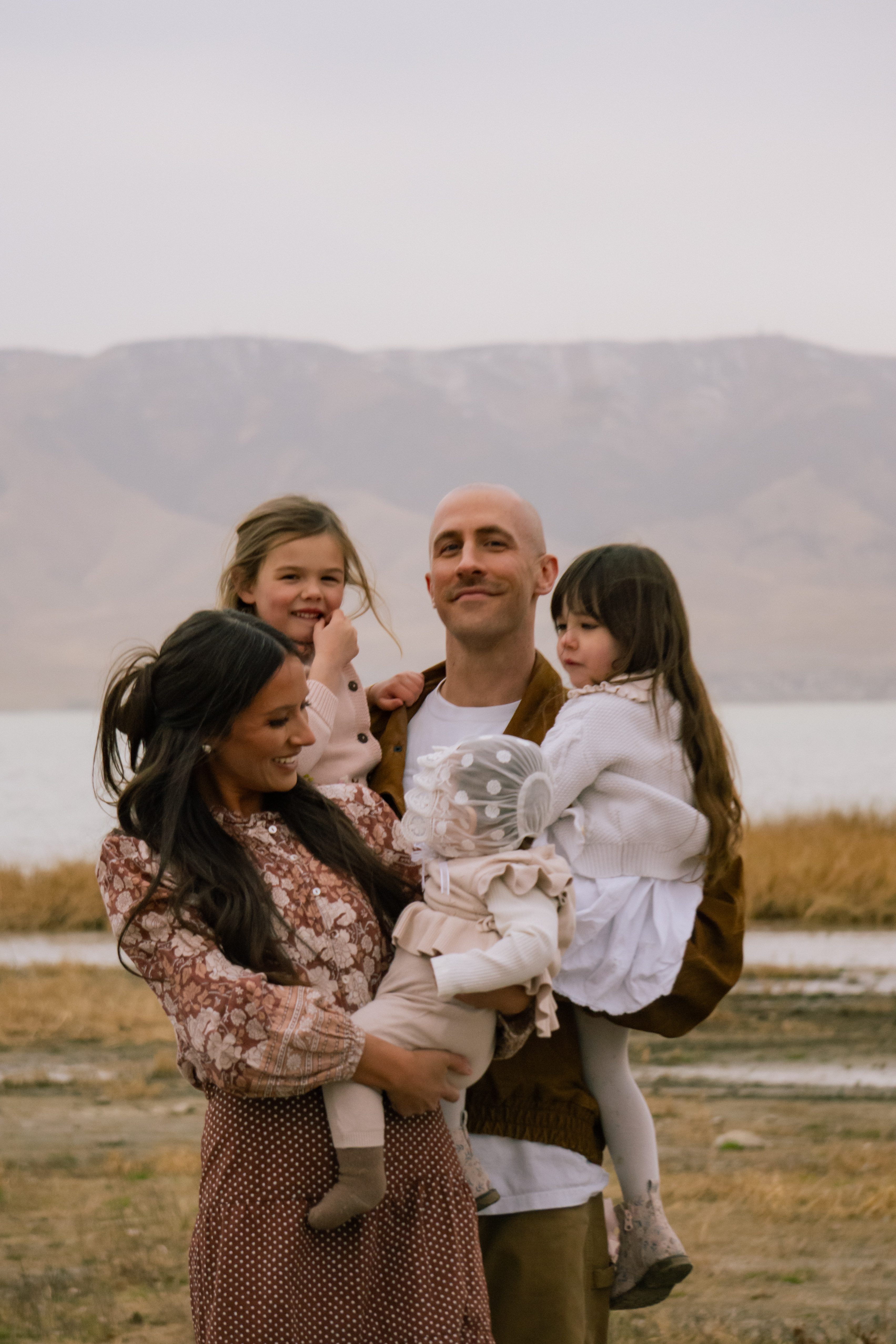 Family photography — family of four together by the lake
