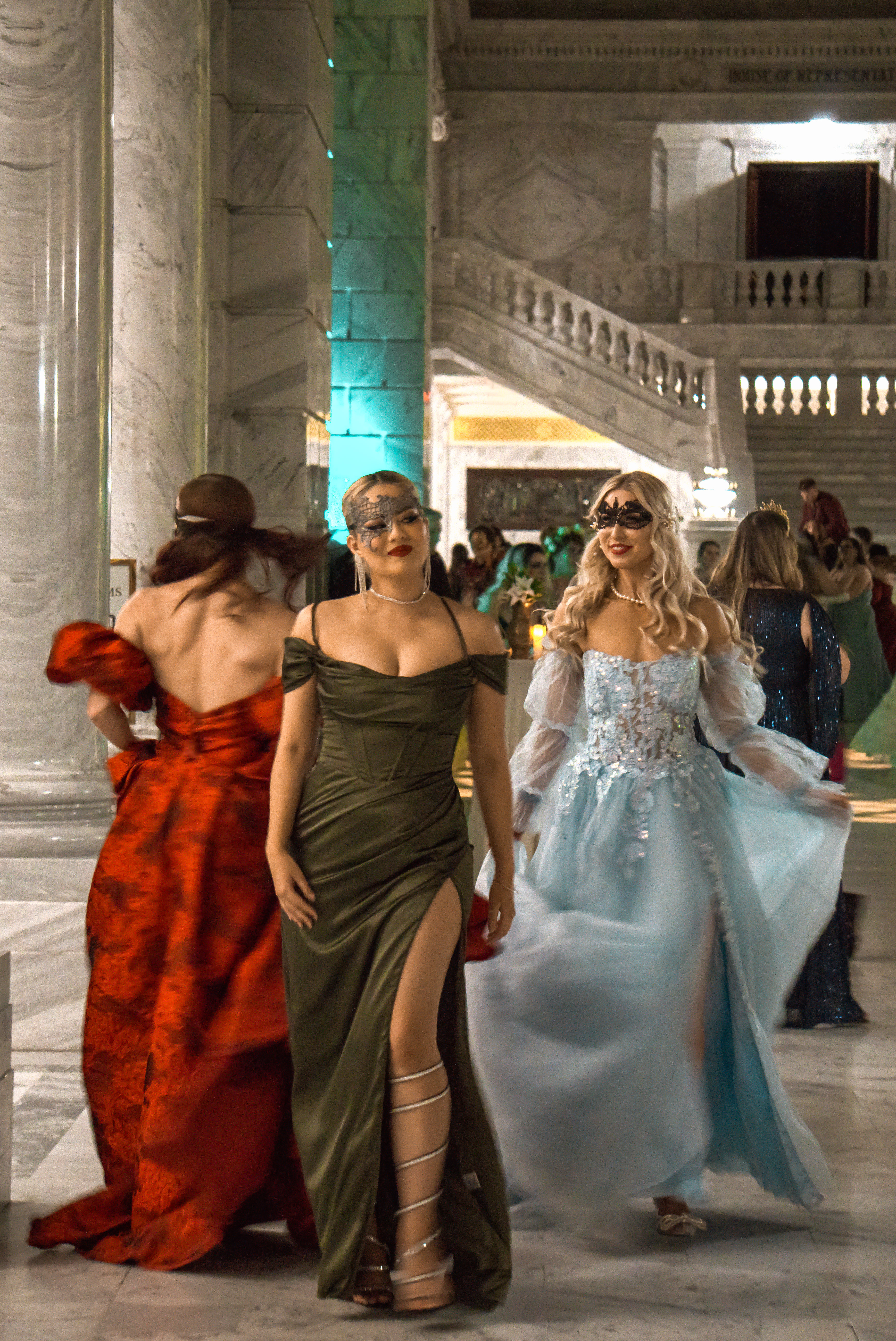 Fashion — Women in elegant gowns at a masquerade ball